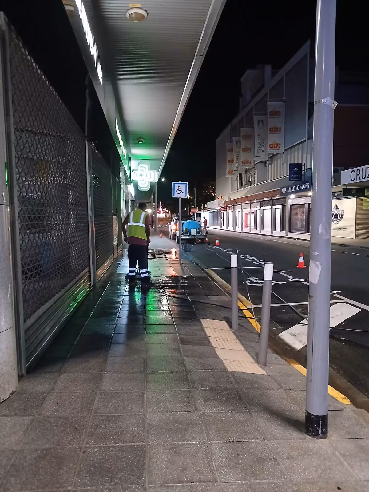 Agent ABC Support nettoyant de nuit les trottoirs et la galerie d'une pharmacie à Nouméa