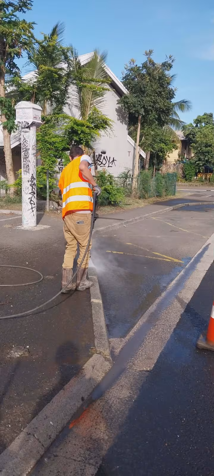 Équipe ABC Support nettoyant à haute pression un trottoir de quartier résidentiel à Rivière-Salée, Nouméa