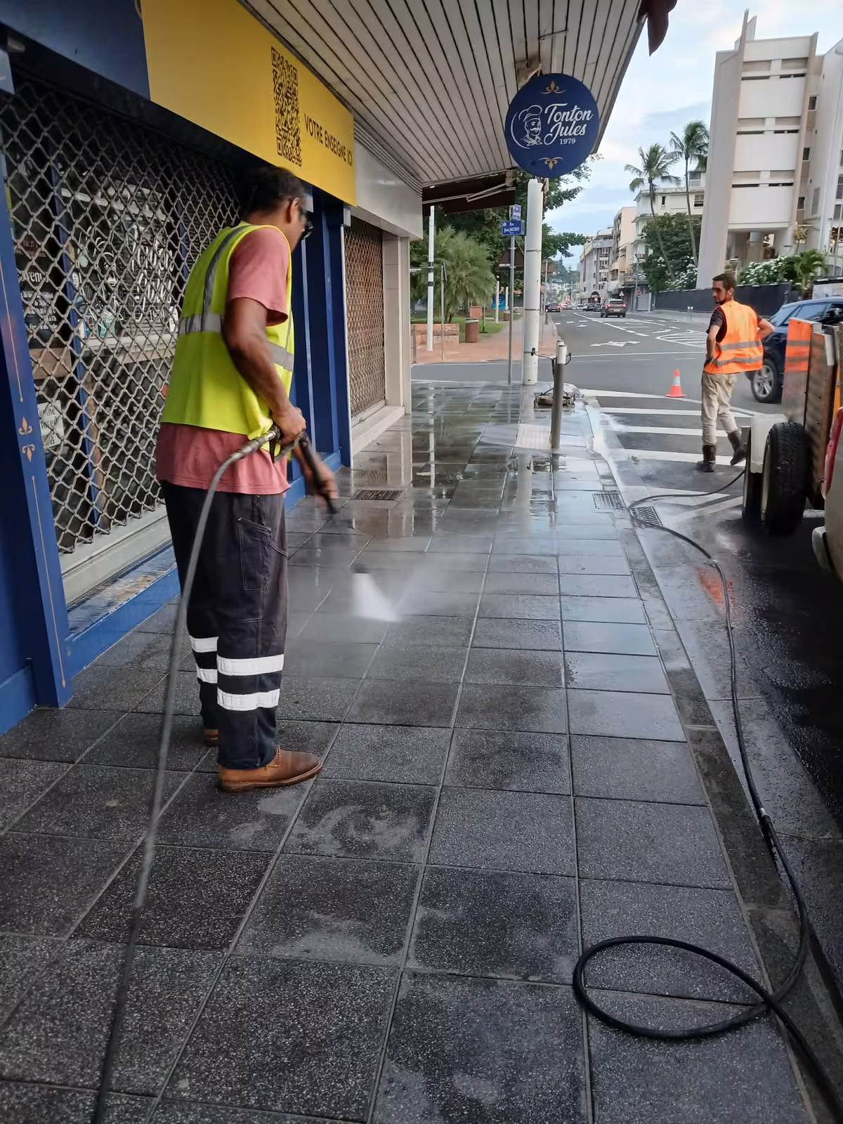 Technicien ABC Support nettoyant au karcher la devanture d'un commerce en bord de mer à Nouméa